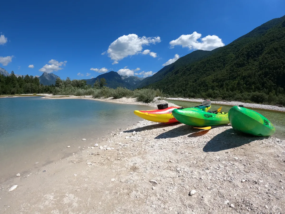 Colorful kayaks on the Soča riverbank